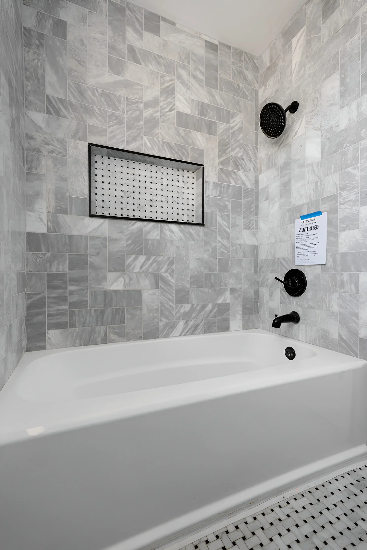 Tub bath with tiled surround and black fixtures