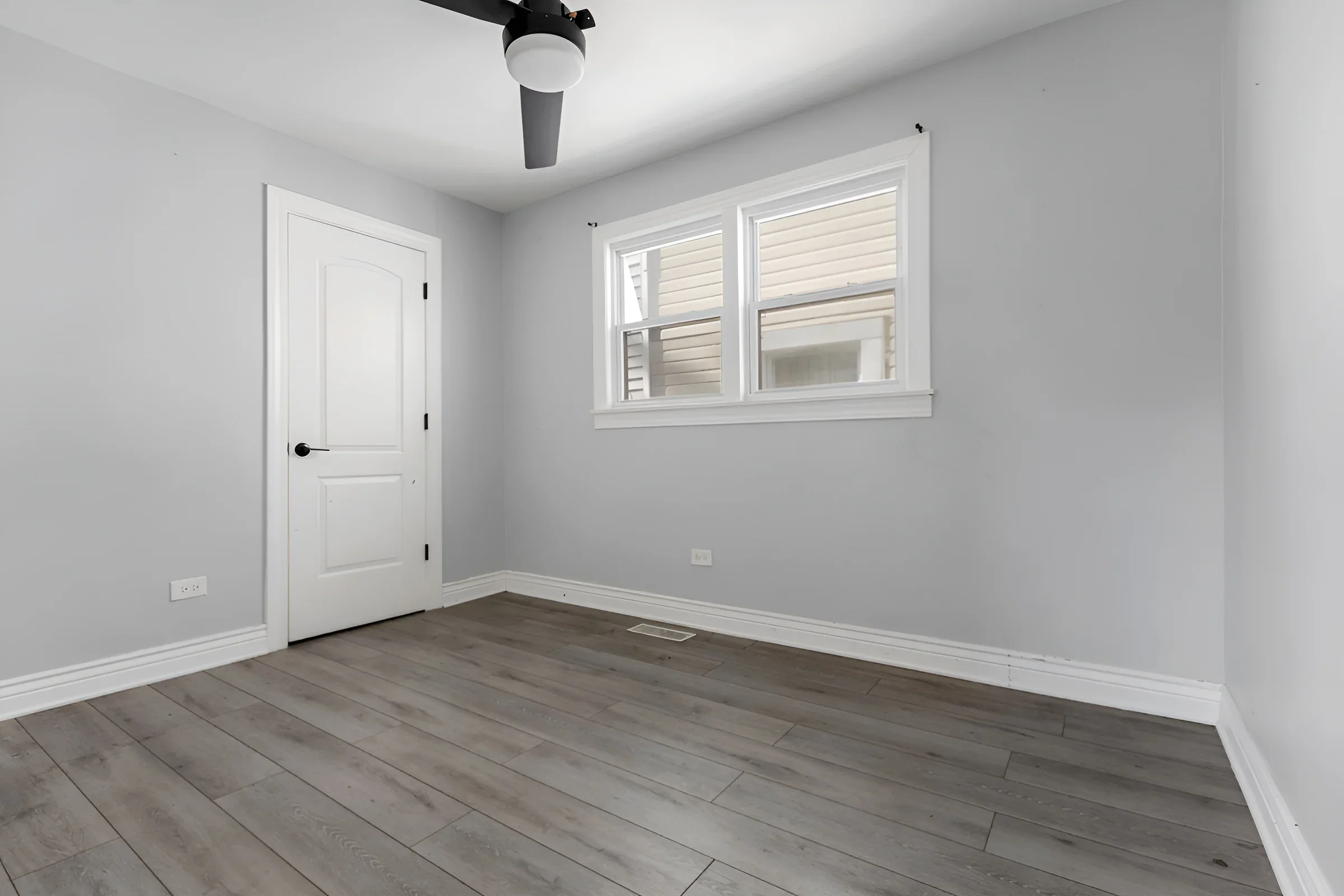 Refinished bedroom with ceiling fan and new wide-plank flooring